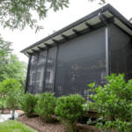 Screened-in porch with landscaping and walkway.
