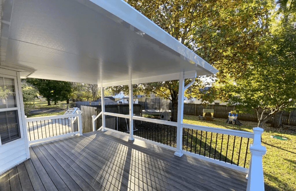 White covered deck with black railing.