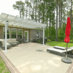 Patio with a pergola and red umbrellas.