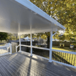 White covered deck with black railing.