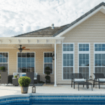 Beige house with covered patio and pool.